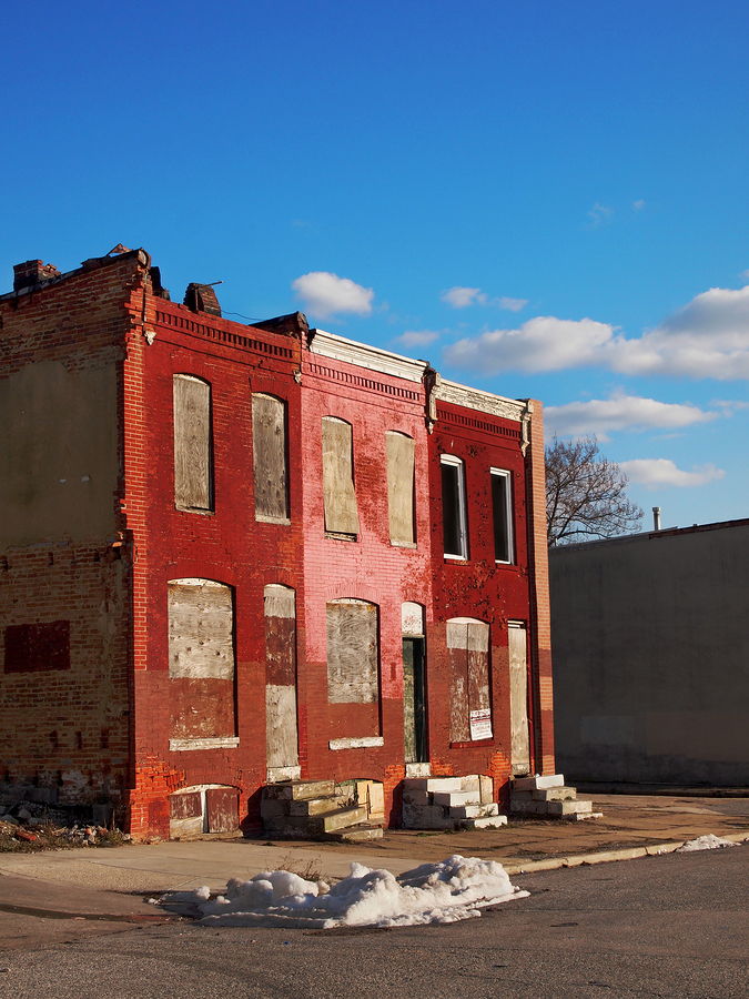 Abandoned block of rowhouses against a blue sky